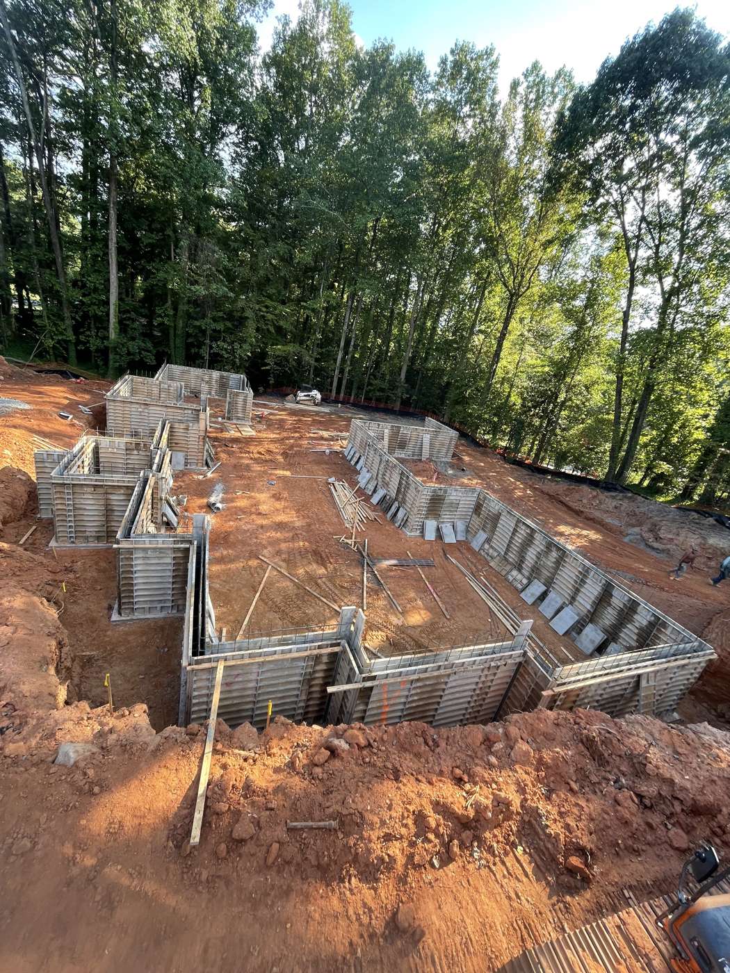 Aluminum wall forms set around a full basement footprint on red clay