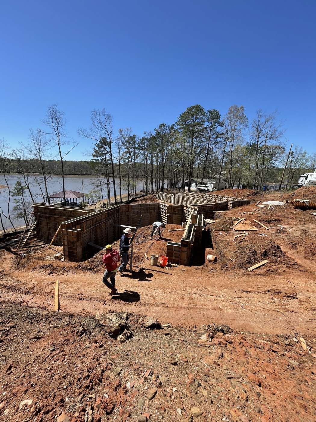 Crew setting aluminum wall forms for a foundation on a lakefront lot