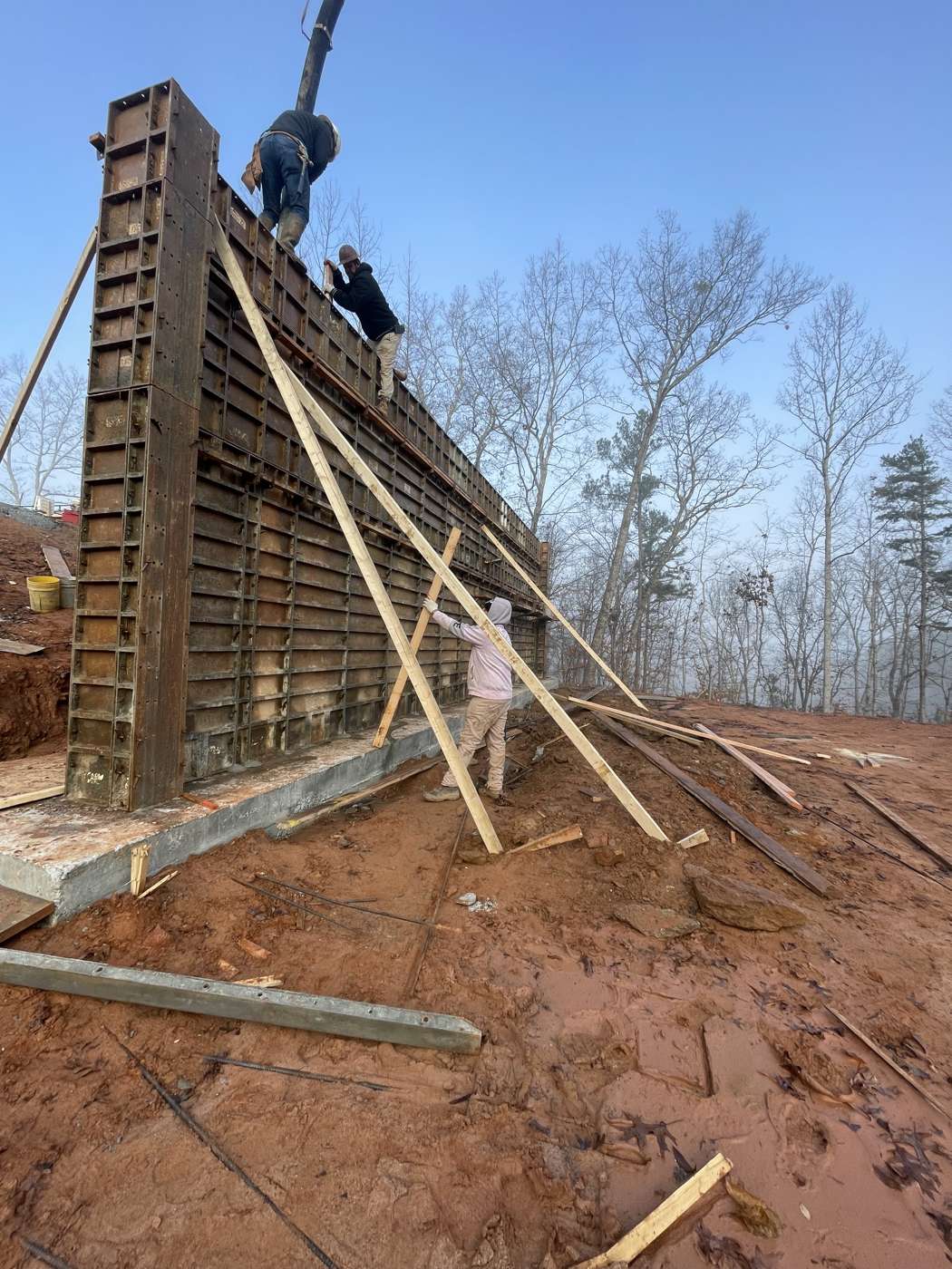Crew on top of tall aluminum wall forms during a concrete pour